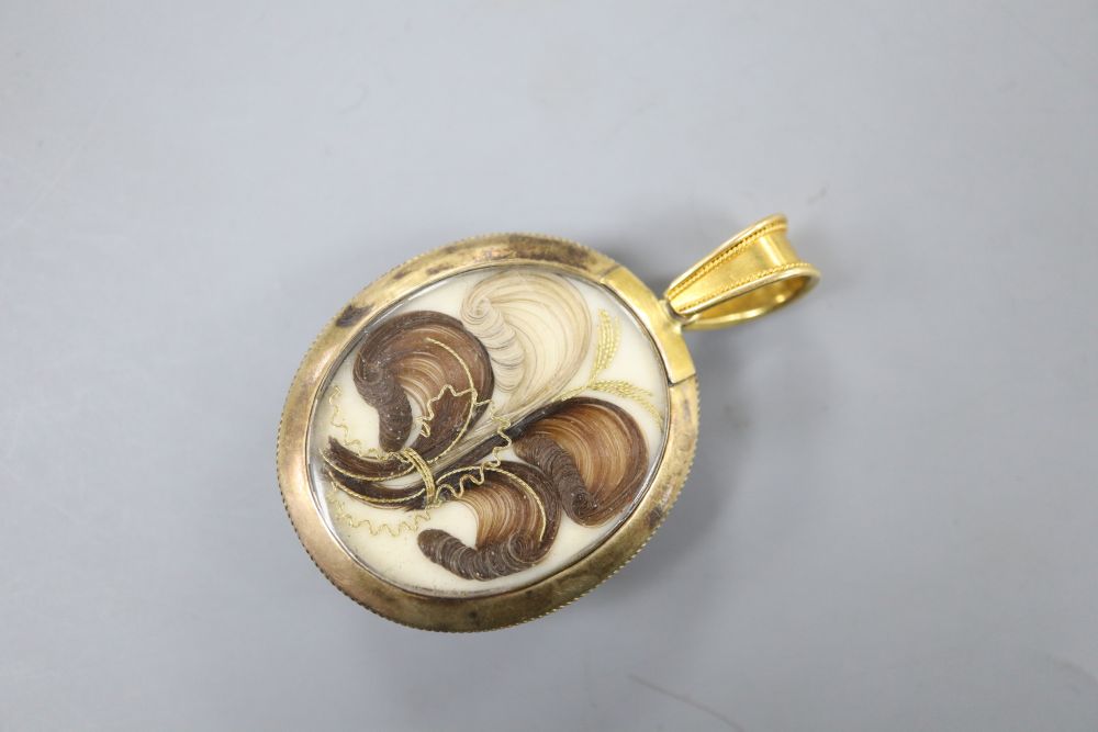 A Victorian yellow metal, banded agate and black enamel oval mourning pendant, with plaited hair verso, overall 54mm,